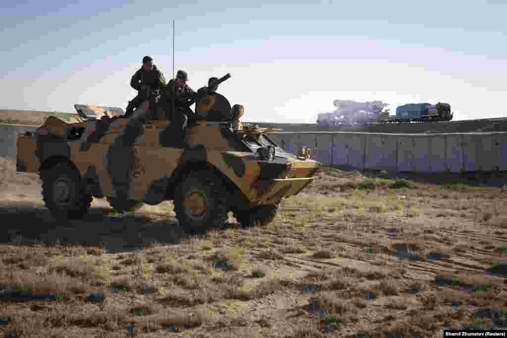 Российские военнослужащие наблюдают с бронетранспортера за транспортировкой &laquo;Союза&raquo; к стартовой площадке. Байконур рассматривается как потенциальная мишень террористических атак.&nbsp;