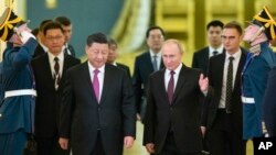 Președintele rus Vladimir Putin (centru dreapta) îl întâmpină pe omologul său chinez, Xi Jinping (centrulstânga), pentru discuții la Kremlin, în luna iunie.