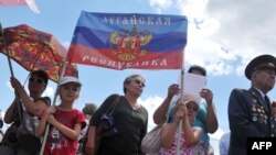 Children hold a flag of the self-styled "People's Republic of Luhansk" during a rally in the eastern Ukrainian city of Luhansk in June.