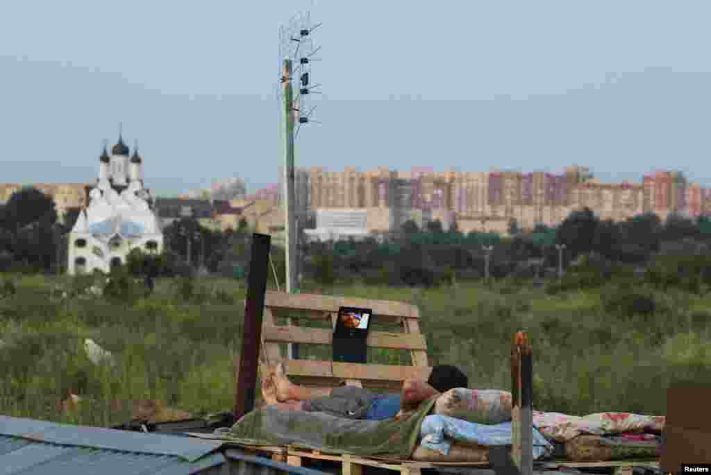 Мужчина смотрит фильм на портативном DVD-player. 2011. 