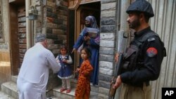 د روغتیا یو کارمند یو ماشوم ته د پولیو واکسین ورکوي - د مې ۲۶مې انځور 