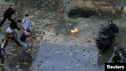 Antigovernment protesters clash with riot police at the Egyptian port city of Suez on January 27.