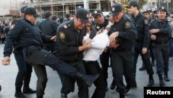 Полицейские задерживают участника оппозиционной демонстрации в Баку. Октябрь 2013 года.