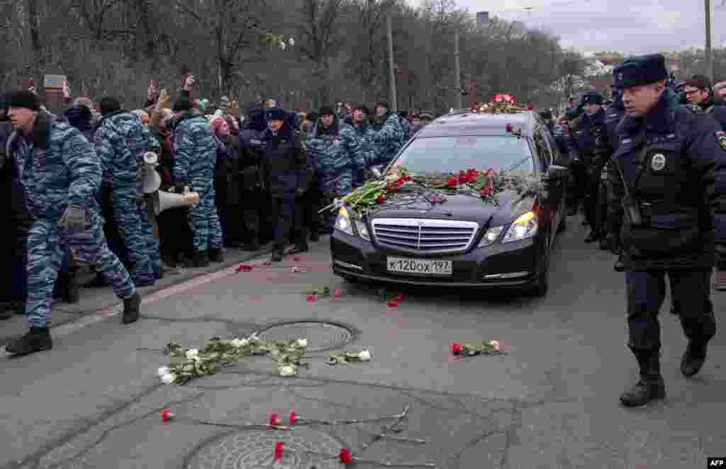 People throw flowers ahead of a hearse transporting Nemtsov's coffin to the cemetery.