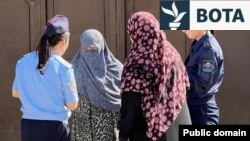 Zyrtaret policore duke biseduar me gratë në Osh lidhur me ndalesën e nikabit. 