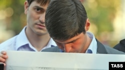 An opposition activist holds a portrait of Magomed Yevloyev during a protest in Moscow last year.