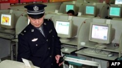 Интернет-кафені тексеріп жүрген полицей. Қытай, 17 маусым 2002 жыл. (Көрнекі сурет)