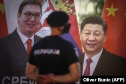 Un polițist stă de pază lângă un banner care îi înfățișează pe președintele Serbiei, Aleksandar Vučić, și pe liderul Chinei, Xi Jinping, în fața clădirii Adunării Naționale din Belgrad, 11 mai 2020.