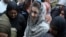 Police officers escort Maryam Nawaz when she appears in an accountability court in Lahore on August 9.