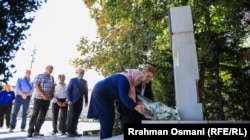 Natasha Sqepanoviq dhe familjarë e aktivistë për të pagjeturit, pranë pllakës përkujtimore për të zhdukurit me forcë, në Prishtinë, më 28 gusht 2025.