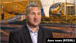 Serhiy Davydyuk, na fotografiji snimljenoj u Kijevu u junu 2025. godine, sa slikom iza koja prikazuje predgrađe njegovog rodnog grada Nova Kakhovka u južnoj Ukrajini.