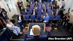 Američki predsednik Donald Tramp (s leđa) na konferenciji za novinare u Beloj kući, ispred predstavnika sedme sile koji su i sami na fizičkoj distanci propisanoj kao mera prevencije širenja korona virusa. 6. april 2020. 