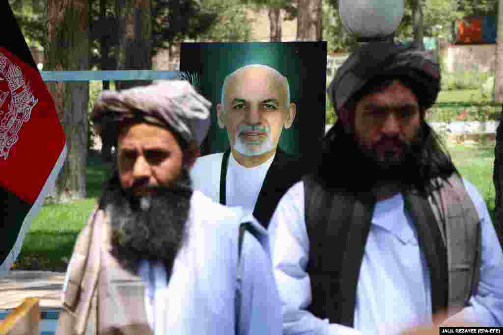 Former Taliban prisoners stand in front of a portrait of Afghan President Ashraf Ghani as they attend a ceremony at the governor&#39;s office after being released by authorities in Herat on May 26.