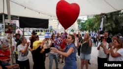 Oamenii se bucură după ce președintele Donald Trump a anunțat că Israelul și Hamas au convenit asupra primei faze a încetării focului în Gaza. „Piața Ostaticilor”, Tel Aviv, Israel, 9 octombrie 2025.
