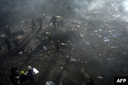 Salvatorii și pompierii intervin la locul unei lovituri rusești în Harkov, 7 martie 2025