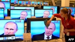 Мәскәүдәге кибетләрнең берсендә Владимир Путин туры эфирда халык сорауларына җавап бирүне күрсәткән телевизорлар. 17 апрель 2014 