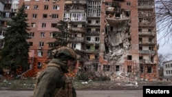 Український військовослужбовець проходить повз багатоповерхівку, пошкоджену внаслідок російських обстрілів, Покровськ, 6 березня 2025 року