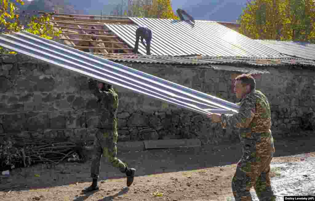 Garo Dadevusian (right) salvages the tin roof from his house in Karvachar/Kalbacar before setting the building ablaze.
