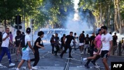 Protestarii fug după lansarea grenadelor cu gaze lacrimogene în confruntările cu poliția la Marsilia, în sudul Franței, la 1 iulie 2023, după a patra noapte consecutivă de revolte în Franța din cauza uciderii unui adolescent de către poliție