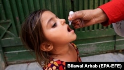 په پېښور کې یوه روغتیايي کارکوونکې یوې ماشومې ته د ګوزڼ واکسیني څاڅکي ورکوي - پخوانی انځور. 