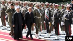 FILE: Iranian President Hassan Rouhani (L) and visiting Afghan President Ashraf Ghani in Tehran in 2015.