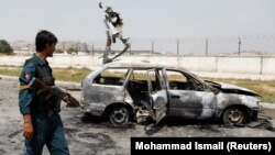 An Afghan police officer inspects a vehicle from which insurgents fired rockets into Kabul on August 18.