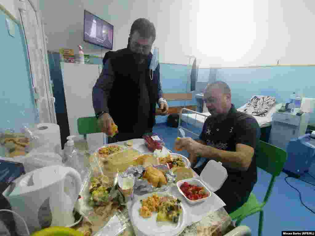 Doru și Daniel, pacienți covid internați la Spitalul &bdquo;Caritas&rdquo; din Roșiori de Vede/Teleorman, iau cina. Pachetele cu mâncare ajung la pacienți cu ajutorul infirmierelor, care o dată pe zi lasă pachetele la ușa fiecărei secții carantinate.&nbsp;