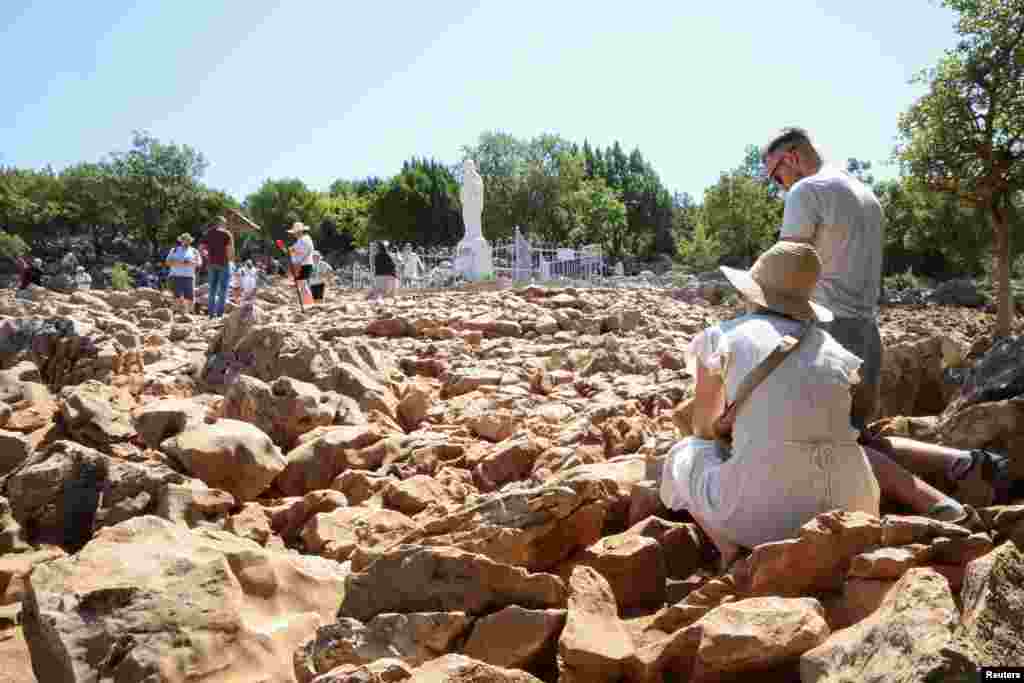 Паломники молятся возле статуи Девы Марии на холме Явления, популярном месте католического паломничества, Меджугорье, Босния и Герцеговина, 3 июля 2025 года.REUTERS/Amel Emric