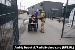 Прикордонник перевіряє документи біля одного з нових модулів КПВВ