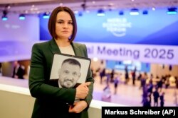 Sviatlana Țihanuskaia ține o fotografie cu soțul ei, Siarhei Țihanuski, la reuniunea anuală a Forumului Economic Mondial din Davos, Elveția, 21 ianuarie 2025.