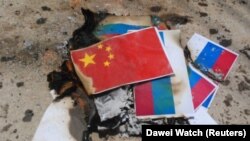 Підпалені прапори Китаю та Росії на акції протесту в одному з міст М’янми, 8 квітня 2021 року
