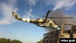 Мі-24 пролітає над військовими поблизу Волновахи, після нападу бойовиків на блокпост української армії 22 травня 2014