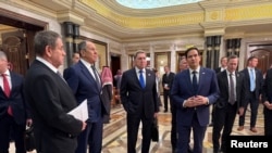 აშშ-ის სახელმწიფო მდივანი მარკო რუბიო, რუსეთის საგარეო საქმეთა მინისტრი სერგეი ლავროვი, რუსეთის პრეზიდენტის ვლადიმირ პუტინის მრჩეველი საგარეო პოლიტიკის საკითხებში იური უშაკოვი და დელეგაციის სხვა წევრები. ელ-რიადი, 2025 წლის 18 თებერვალი.