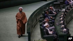 An Iranian cleric lawmaker walks at the parliament during a memorial, in Tehran, Iran, Wednesday, May 21, 2025