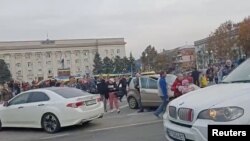 Locuitorii din Herson îi întîmpină cu urale pe militarii ucraineni care sosesc în mașini în piața centrală din Hersson, 11 noiembrie 2022.
