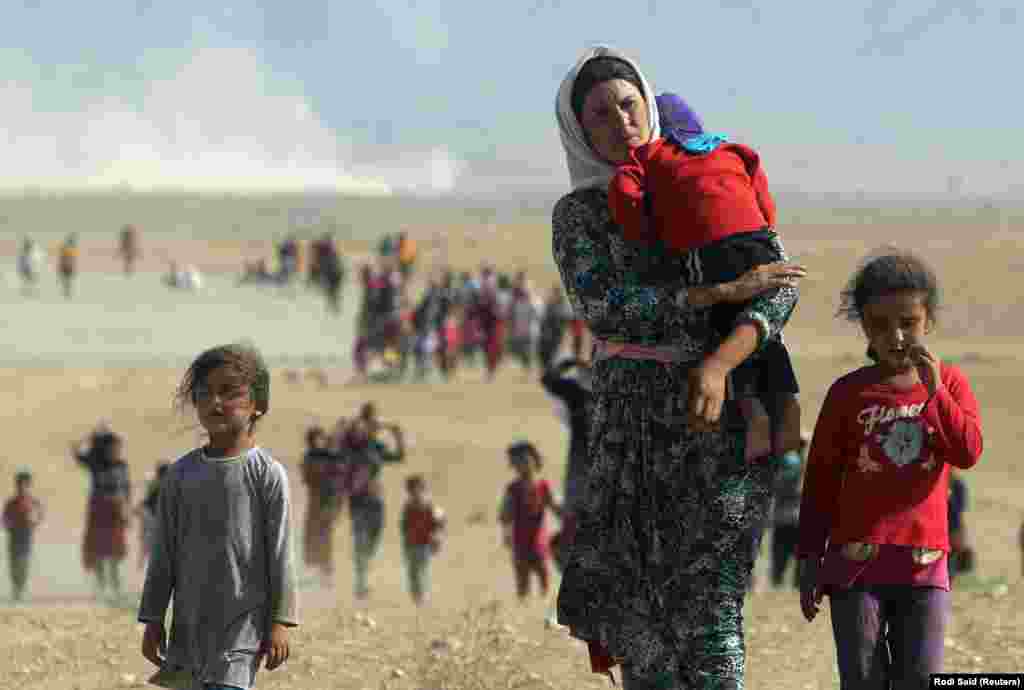 Oameni din minoritatea Yazidi, din orașul irakian Sinjar, fugind de violențele militanților Statului Islamic. 11 august 2014. (Reuters/ Rodi Said)