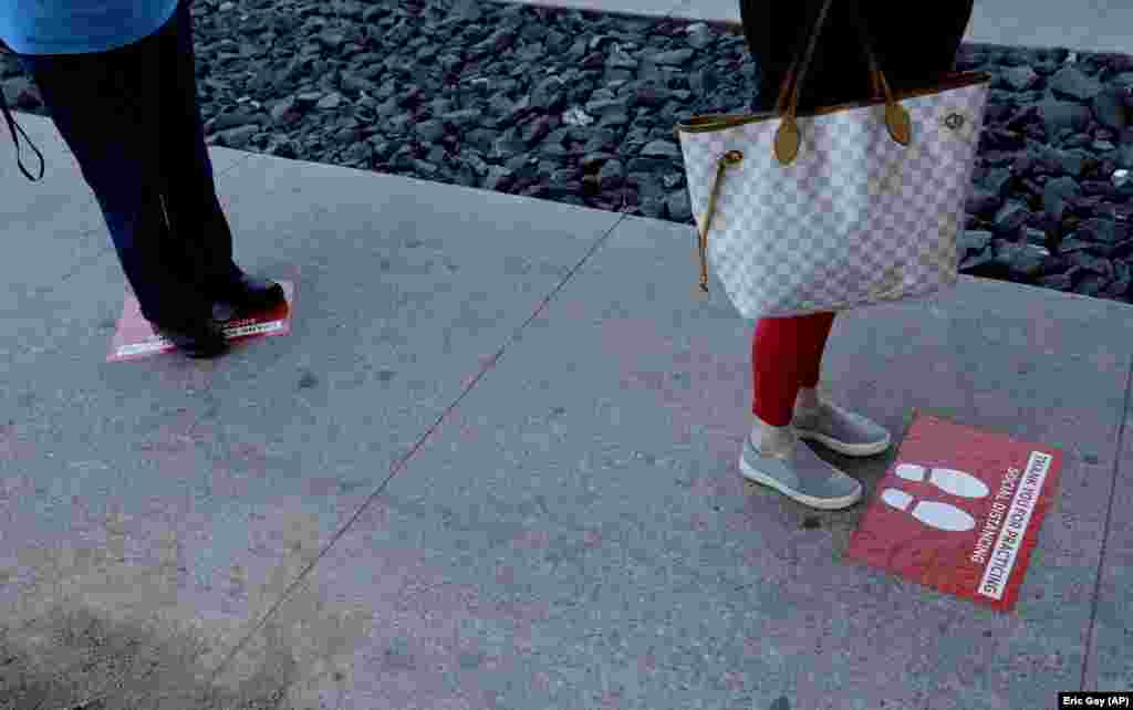 Позначки, що допомагають дотримуватися дистанції у черзі до продуктового магазину в Остіні. Штат Техас, США, 25 березня 2020 року