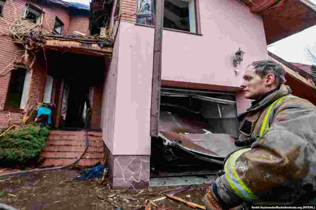 Пожежник біля пошкодженого внаслідок російського обстрілу будинку. Село Гатне, Київська область, 3 березня 2022 року