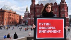 "Putin. Offshore, Impeachment." -- A lone protester holds up a sign in Moscow protesting over the fact that Russian President Vladimir Putin is seen to have been implicated in murky financial dealings revealed in the Panama Papers