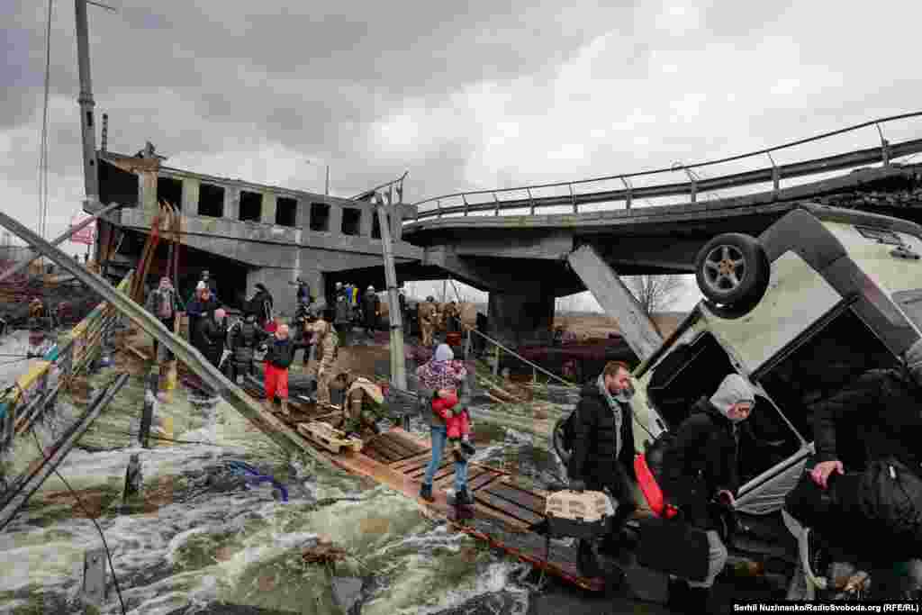 Весь світ облетіли кадри, як люди тікають від російських військ, перетинаючи річку по уламках Романівського мосту і дерев'яних трапах.При цьому російська армія обстрілювала цей шлях евакуації цивільних. Ліворуч фото від 7 березня 2022, праворуч – березень 2025 року