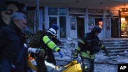 Salvatorii cară un civil după ce o rachetă rusească a lovit o clinică privată din Zaporojie.