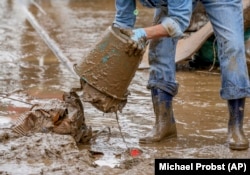 Oamenii au început să scoată nămolul din case în Bad Neuenahr-Ahrweiler, Germania. Râul Ahr a inudat o mare parte a orașului.