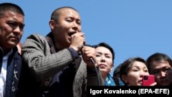 Businessman Tilek Toktogaziev (second from left), whom protesters demand be named as the country's new prime minister, speaks to people gathering in Bishkek on October 7.