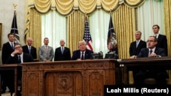 Predsednik SAD Danald Tramp nakon potpisivanja sporazuma, a tokom pres konferencije, između presednika Srbije Aleksandra Vučića (levo) i premijera Kosova Avdulaha Hotija (desno). Bela kuća, 4. septembar 2020.