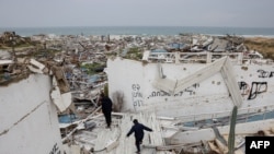 کودکان روی ساختمان‌های ویران در شهر غزه در جریان آتش‌بس کنونی دیده می‌شوند.
