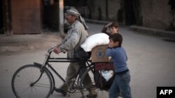 یک مرد سوری در حال انتقال مواد غذایی که از سوی برنامه غذایی جهان برای افراد بی‌بضاعت در سوریه کمک شده است.