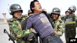 Кытай полициясе Өремчедә бер уйгырны тоткарлый (архив фотосы)