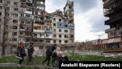 Поліцейський з підрозділу «Білий ангел», який евакуює людей з прифронтових міст і сіл, супроводжує мешканців під час евакуації у Покровську, 12 квітня 2025 року