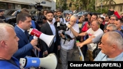 Având în mână o portavoce roșie, ministrul Economiei, Radu Miruță, vorbește cu protestatarii de la Damen Mangalia. București, 24 septembrie 2025.