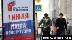 Oameni trecând pe lângă un panou publicitar în Novosibirsk. 10 iunie 2020